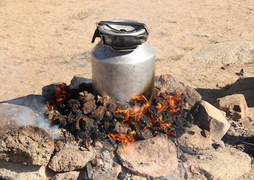 Two goats in milk can pressure cooker on horse poop fire, Ikh Nart Nature Reserv
