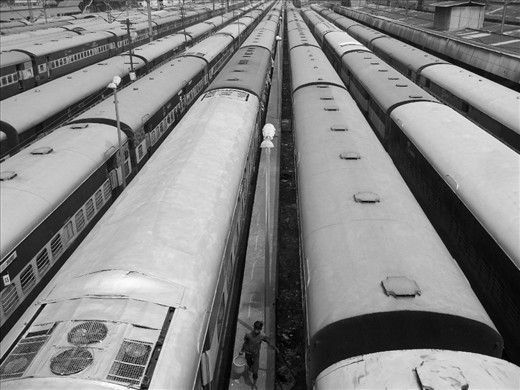 Trains are getting ready for their journey to start. Few are on their respective platform, while most in this scene are not on the platforms -as they are done with their part of the journey ans getting ready for the next one. and has been parked onthe side tracks. A young boy is seen is seen in this pic which was cleaning windows of the bogies from outside with a bucket full of water. 
