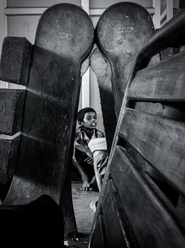 This boy represent all the boys who lives at the station and make there living out of the rages-water bottles, contains, papers- thrown by the passengers on to the platform or on the railway tracks. They risk there lives to collect the waste from the tracks, so that they can sell it and  earn something out of it. Usually whole family is involves in this task. Many a times members from different families fight over the collect just a simple plastic bottle thrown by the passenger. This boy was having some quite time sitting with his mates after collecting some plastic bottles.