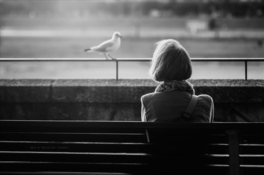 Loneliness. A lady deep in thoughts sitting and lookind the river.