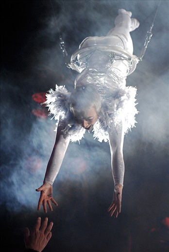 Opening Ceremony. A hand from the audience tries to touch the flying acrobat.