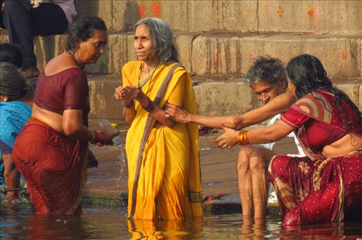 A woman taking a ritual bath at the Ganges river, India.