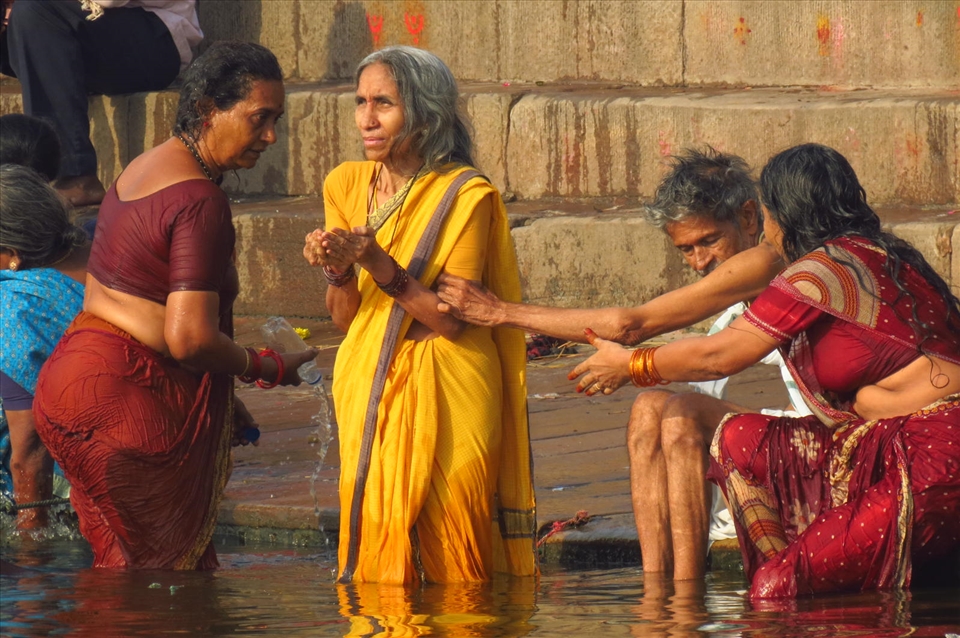 A woman taking a ritual bath at the Ganges river, India.