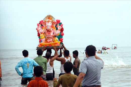 Men bring a statue of the Hinud god Ganesh into the water at Chowpatty beach, Mumbai. After bringing the statue of Lord Ganesh to the Ocean, they will then immerse the statue in water, drowning it, in tribute to the God.