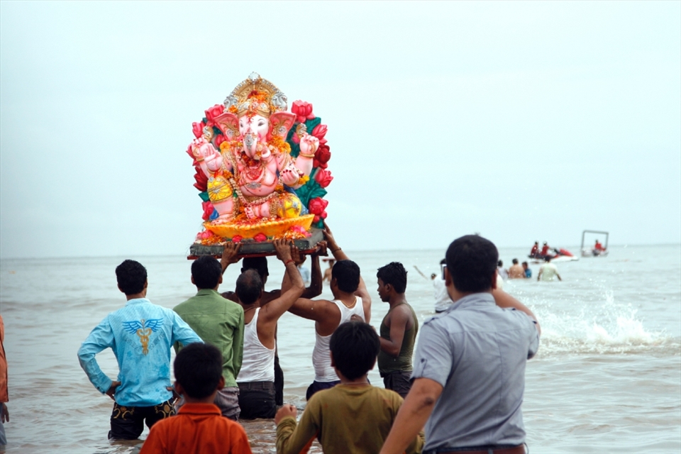 Men bring a statue of the Hinud god Ganesh into the water at Chowpatty beach, Mumbai. After bringing the statue of Lord Ganesh to the Ocean, they will then immerse the statue in water, drowning it, in tribute to the God.