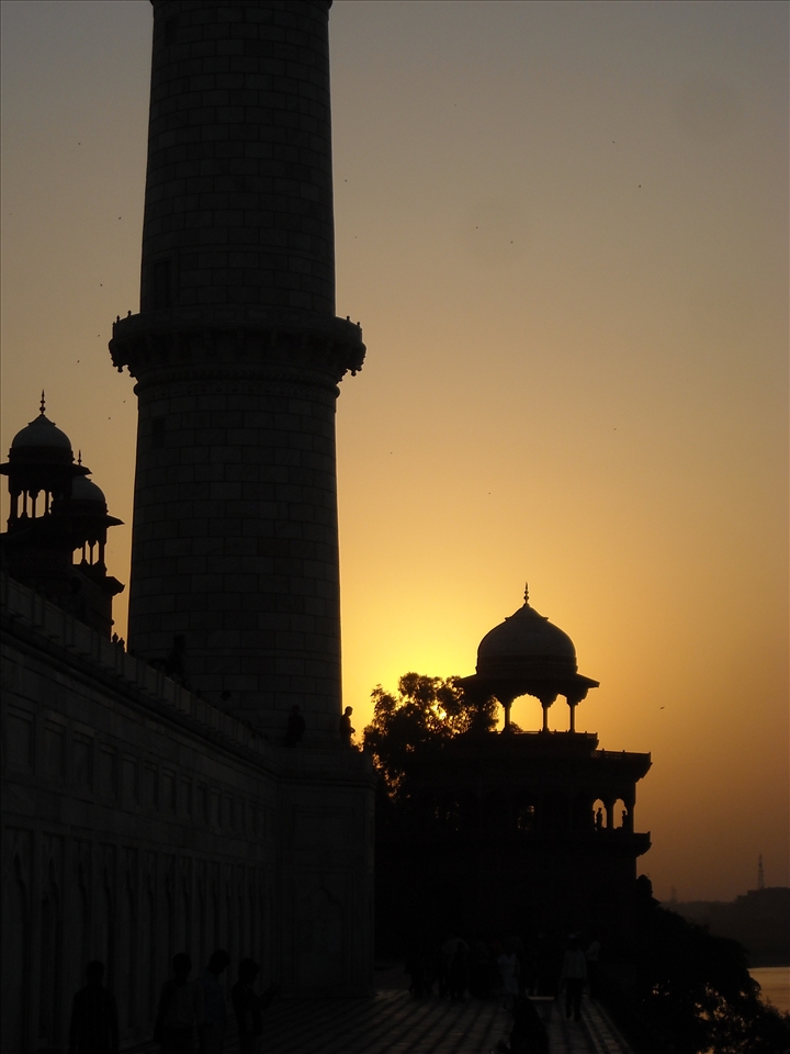 sun sets just at the back wall of taj over the bank of yamuna. 