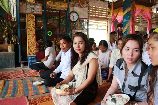 People from the village gather at temple to celebrate the end of the dry season and the coming of the rainy season which they call the cross season. That hot and sunny Sunday in April at the small village of Somrong all the people gather, even those that moved to the city in search of a better life returned that day to celebrate with their families. The temple was built by famous monk Ven. Somnieng Hoeurn who was born there and held the ceremony that day. Each person has a bowl of rice which they patiently hold during the ceremony after which they donate it to the monks.  
Custom dictates that women should cover their shoulders, they usually do this with white handmade lace scarf. 
