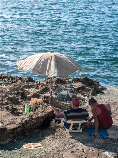Cubans on the rocky beach by the Malecon in Havana, Cuba
