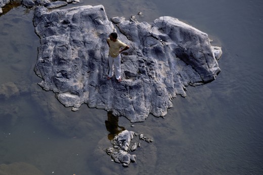 In a middle of river man was satnding in a big stone with his own
