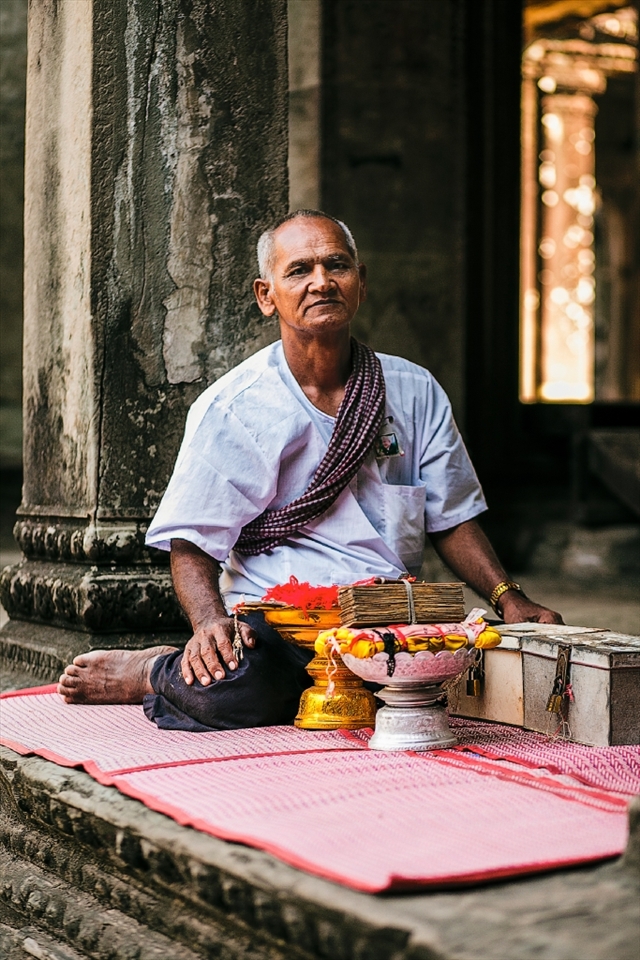 A Buddhist monk sits beside a plethora of handmade bracelets in return for a small donation to the temple.

Angkor Wat,  Cambodia.