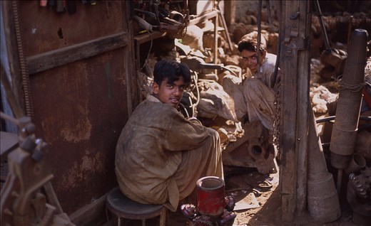 Children workers in a metal shop. Sadly but childhood is exchanged with heavy labor - priceless support for their families. My flat is on a street lined with metal shops, and every morning an adolescent kid walks the alley pulling a speaker's magnet tumbling at the end of a rope and collects the metal scraps sticking to the magnet surface.