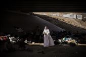 An elderly Yazidi woman walks among a makeshift camp under a motorway bridge.: by vlecaer, Views[225]