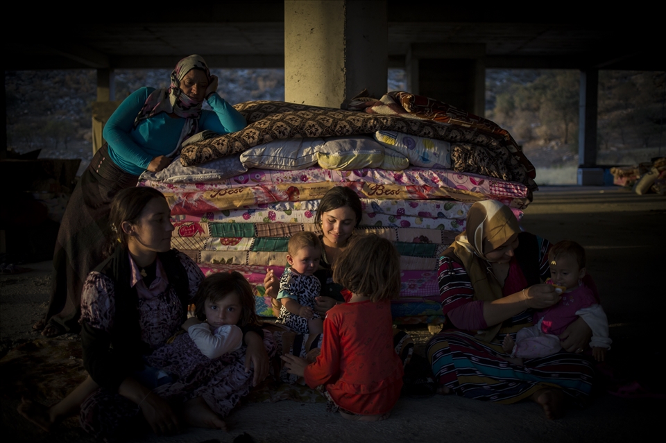 Yazidi mothers care to their children in an unfinished building.