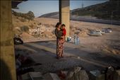 A young Yazidi mother carries her child in her arms inside an unfinished buildi: by vlecaer, Views[202]