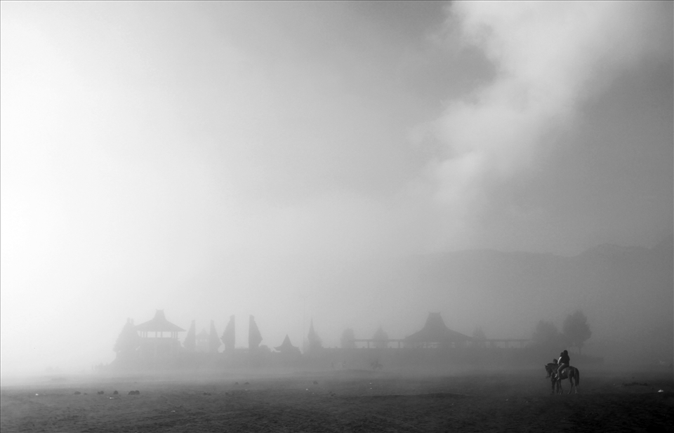 the horsemen between in the temple and the fog of Mount Bromo
