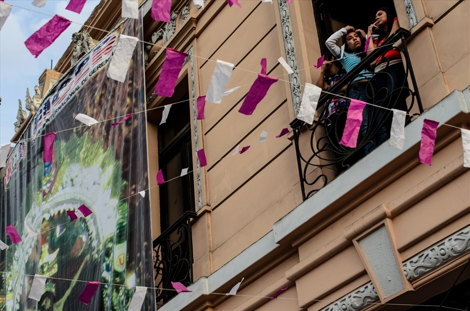 Girls view the procession from their balconies. 