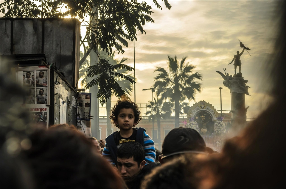 Child on his father's shoulders during procession of Señor de los Milagros