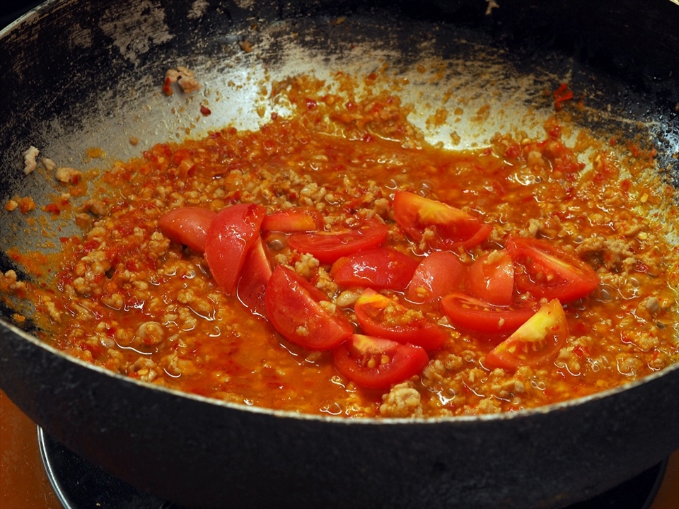 Chopped tomato mixes with chilipaste and minced pork