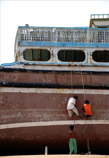 3 playful boys climbing up the lighter(ship)