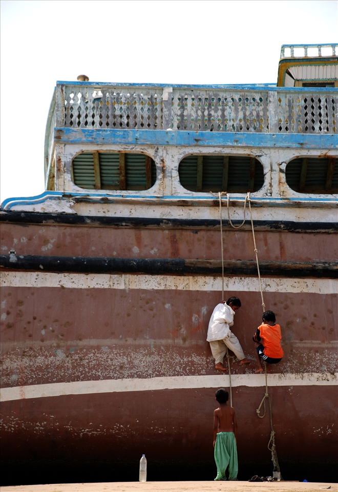 3 playful boys climbing up the lighter(ship)