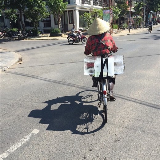 A lady taking delivery of ice. Going back home or to work place. 