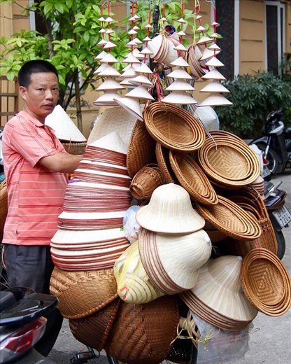 Hat vendor taking his wares to sell. 
