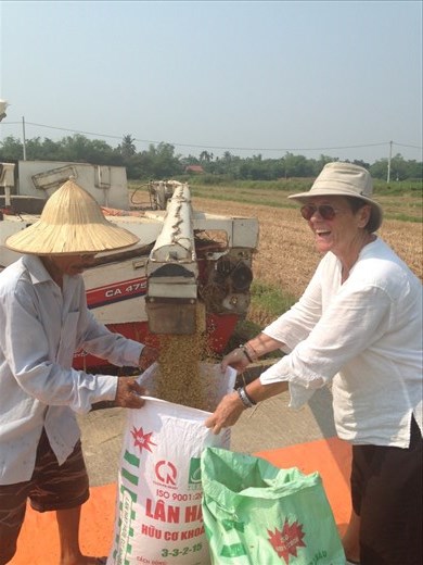 Monika helping the man fill the bags with rice from the harvester. 
