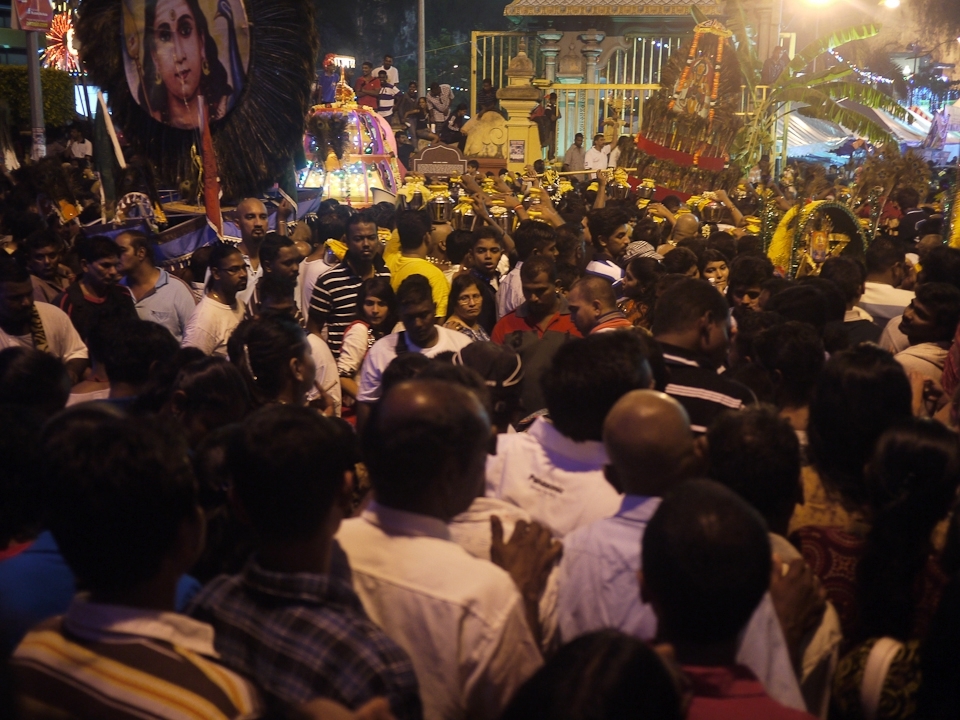 A cacophony of drums and horns, chanting and singing and a thousand conversations in foreign tongues. The shadows from a thousand lights and raised torches. The smoke from charcoal fires, braziers and cigars. The smells of incense, frying meat and vegetables and the sweat of a few hundred thousand people crammed into the area at the base of the steps to Batu Caves. This is Thaipusam!