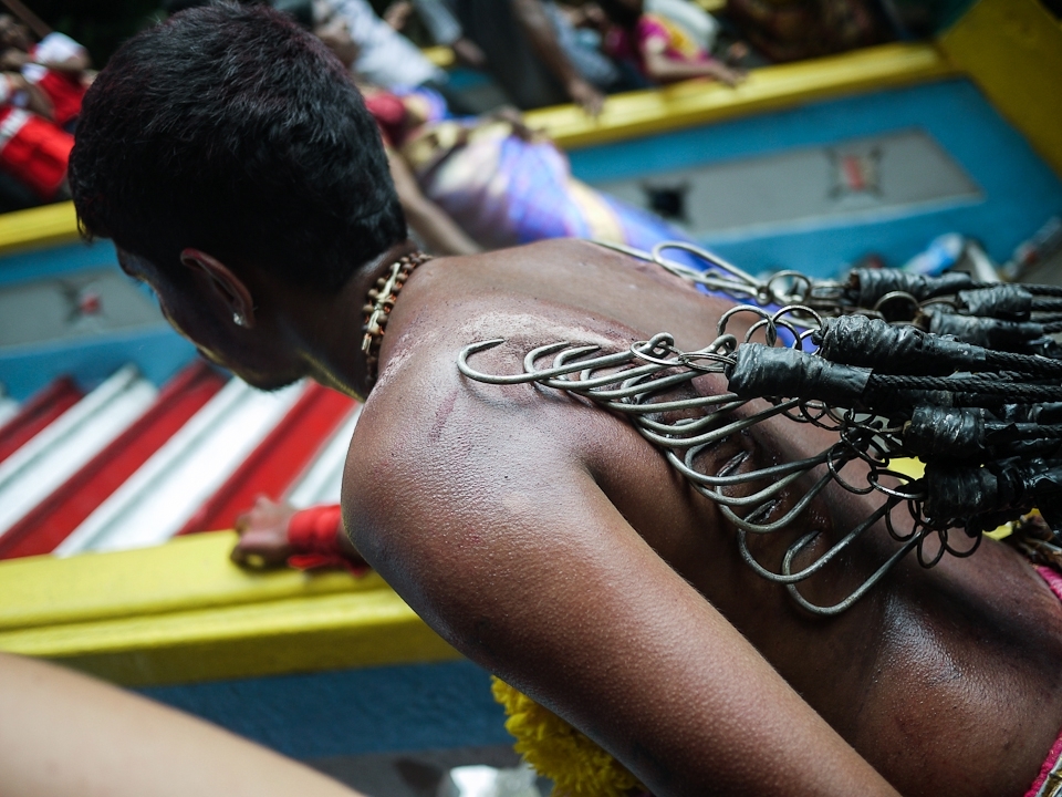 The devotee must the make the long, slow and painful walk from the area of preparation, carrying his or her kavati through the masses of people and slowly up the 272 steep and crowded stairs to the temple complex of Batu Caves.