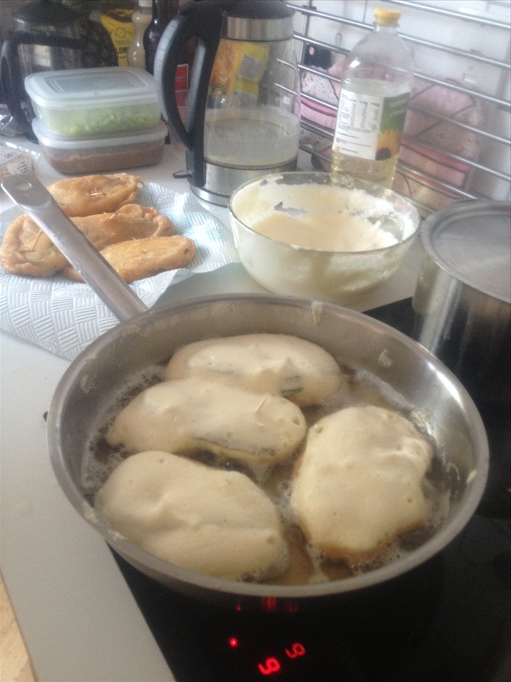 Frying the battered stuffed cactus till golden brown.