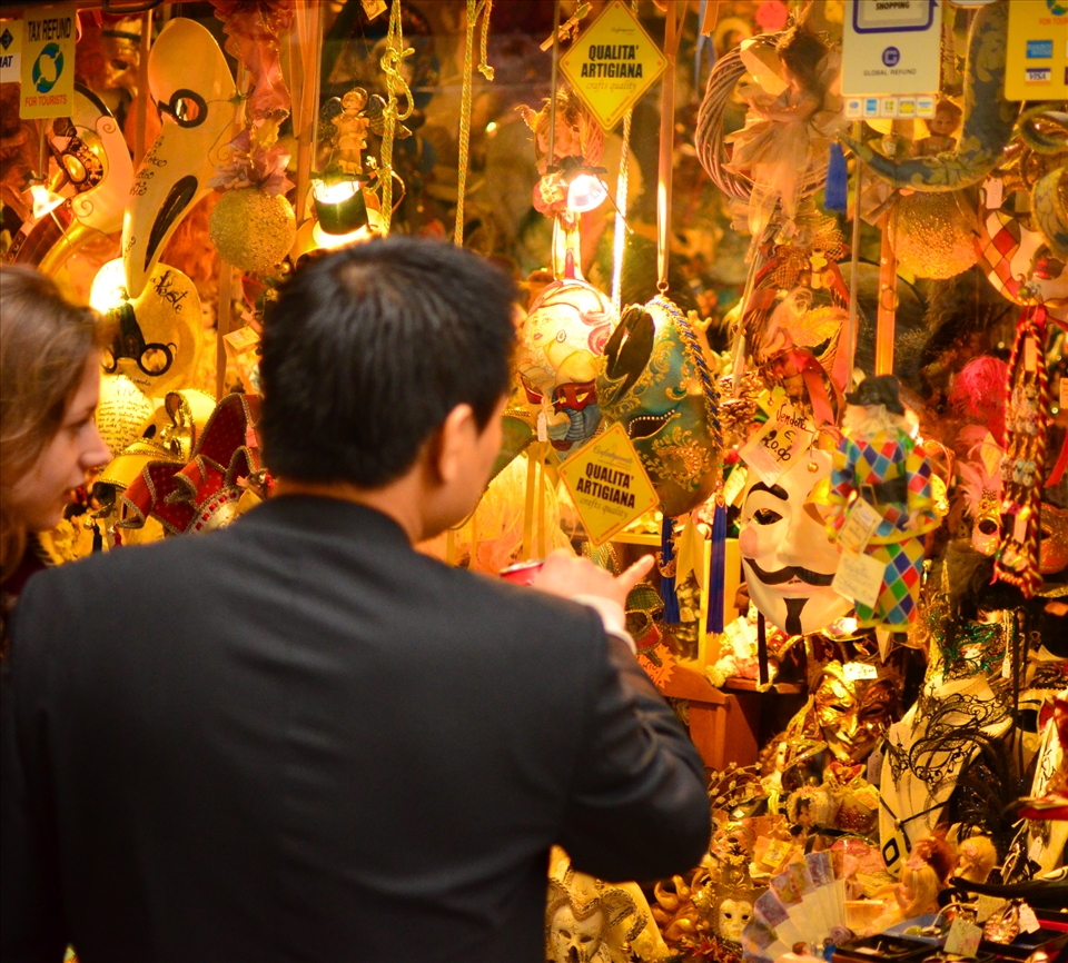 A tourist picks out a Guy Fawkes mask with his partner. Every year Venice celebrates the legendary Carnivale festival, where the masqueraders take to the streets in their lavish costumes. Each outfit is topped off with a stunning mask. Some sequinned and gentile and others downright haunting. Choosing the right one is crucial to the role you wish to portray. 