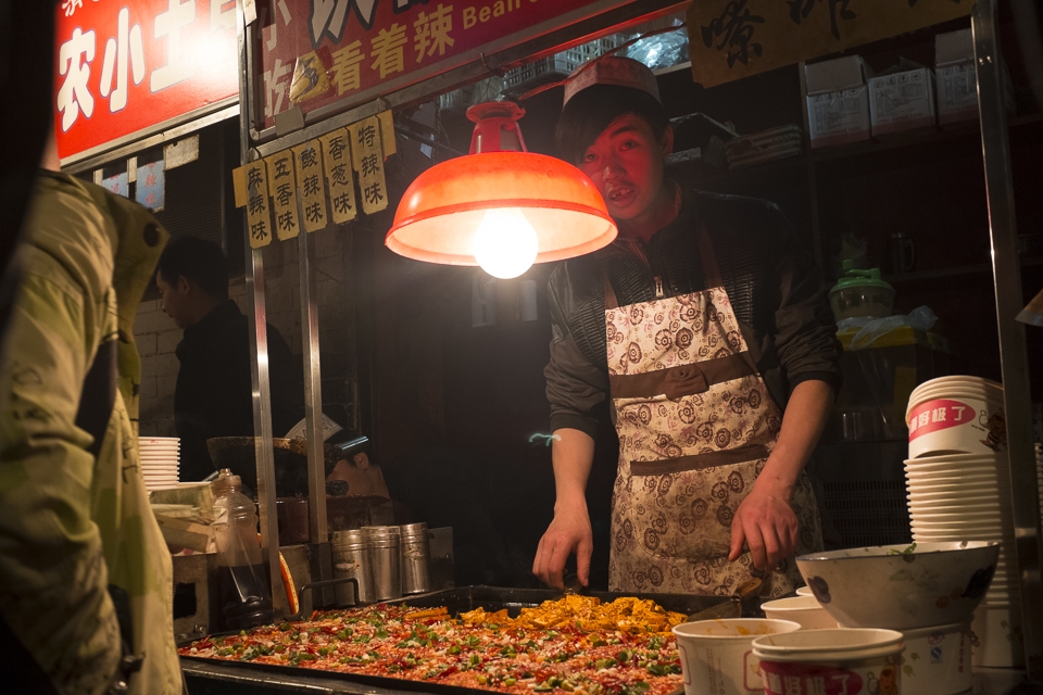 Young Chinese Muslims often spend their evenings working in their family's small business, making and serving an endless supply of treats. Fried tofu and vegetables are some of the favourites.   