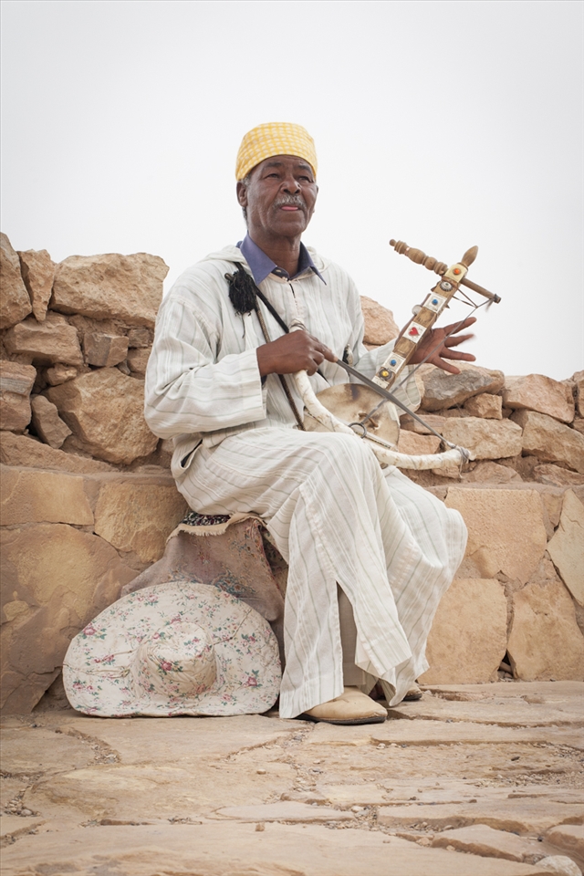Every day this street musician fills the heavy afternoon air with the lightest and chirpiest melody, playing his one string Berber lute. He was so immersed in the beauty of his tune that he forgot to lay down his hat for tips. His heart sang through the lonely string.