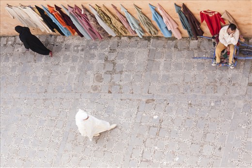 The robe seller was seemingly bored by people wearing only black and white. He didn’t have a real shop - sitting on a rusty old wheelbarrow, he used the wall to showcase his colourful and inexpensive collection of second hand robes. Intoxicated by the early afternoon heat, he still stood there so that he could earn enough to get by and show Moroccans that they don’t have to be rich to wear beautiful and colourful robes.