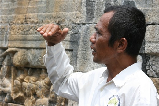 The guide will help you to understand the history of Borobudur temple. He tells of relief on the wall. (Borobudur, Magelang, Central Java)