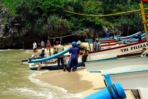 fisherman back from sea in the morning. one boat can hold 2-5 fishermans. when they made to beach, the other people may to help the to up the boat to the land.