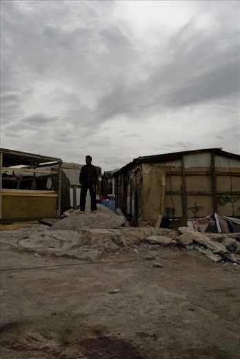 Like a shadow, a man stands, looking at the storm to come