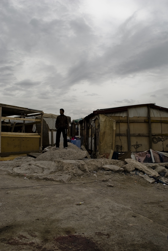 Like a shadow, a man stands, looking at the storm to come