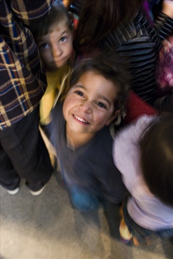 Children smiling at the camera while playing games with an educational team. 