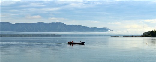 Lumban Silintong, North Sumatera, Indonesia. A fisherman with a boat is trying to catch fish. Professional fishermen are the majority population in Lake Toba vicinity.