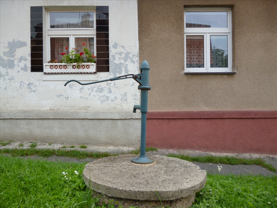 An old water pump sits outside a simple and happy home in Prague. 