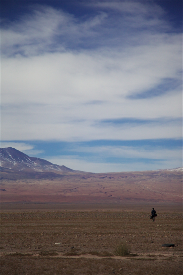 A traveller submits himself to the landscape of the Atacama Desert.