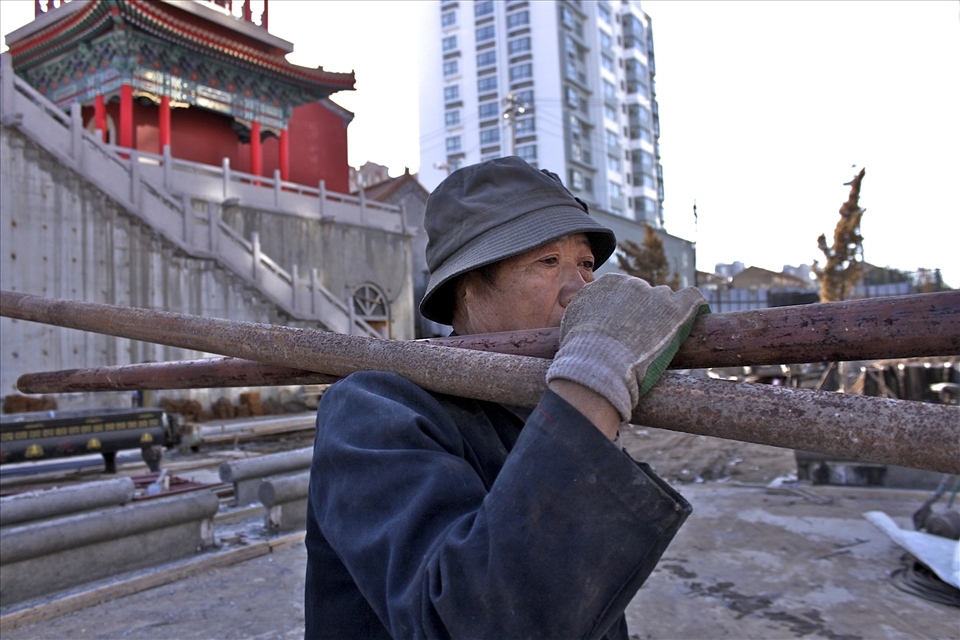 Migrant workers leave their families behind to find work in the city. This man’s face appears to be painted with emotion as he looks out beyond. Perhaps he is lonely and missing his family, or feeling emptiness from monotonous work.