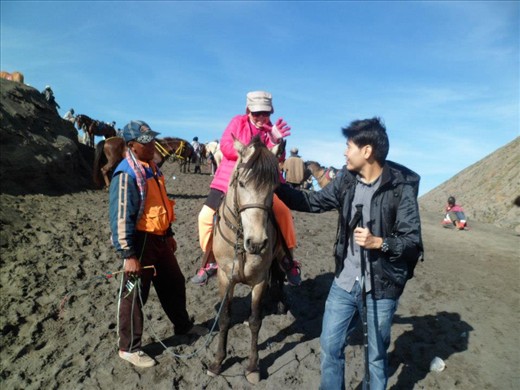 Win is helping his sweet pink-mother to ride a horse down from the crater