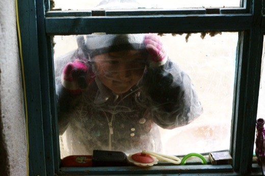 A boy looks inside as his family is packing for departure.