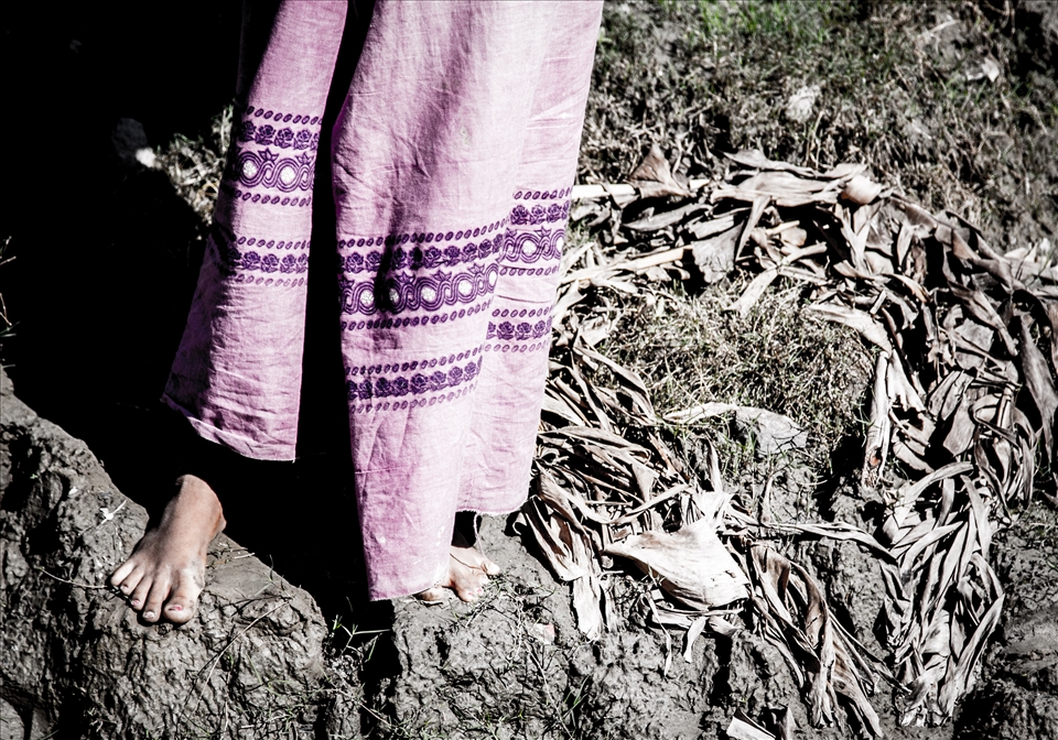 A young girls skirt contrasts with bank of the Irrawaddy river. (Myanmar)
