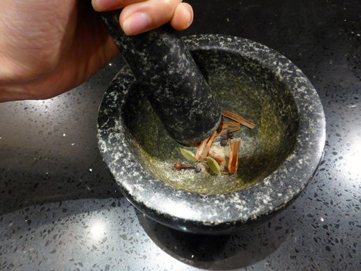 Crushing the spices with a mortar and pestle