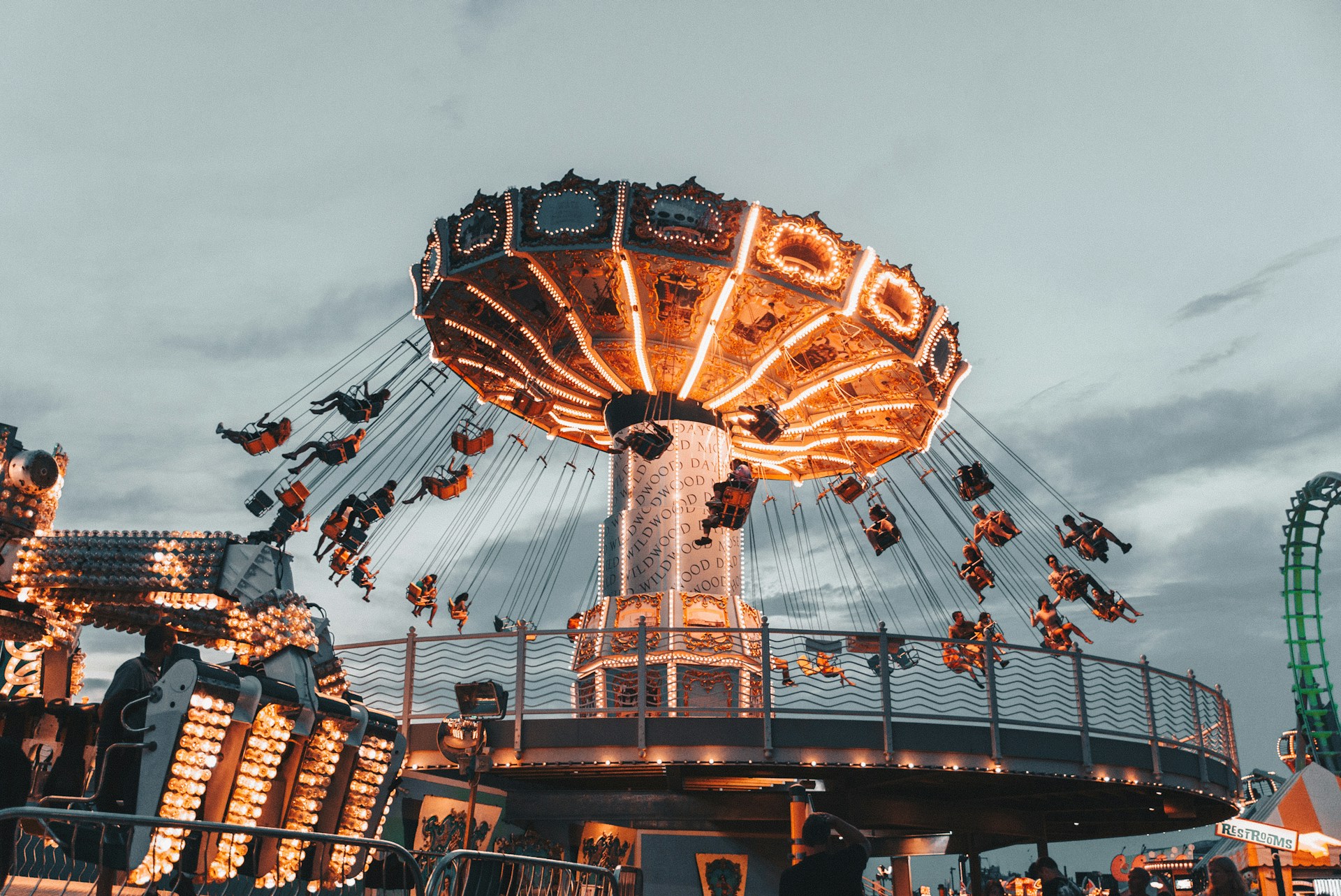 A well-lit swing carousel spinning around at sunset.