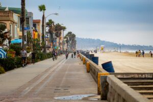 people walking on beachfront sidewalk in daytime