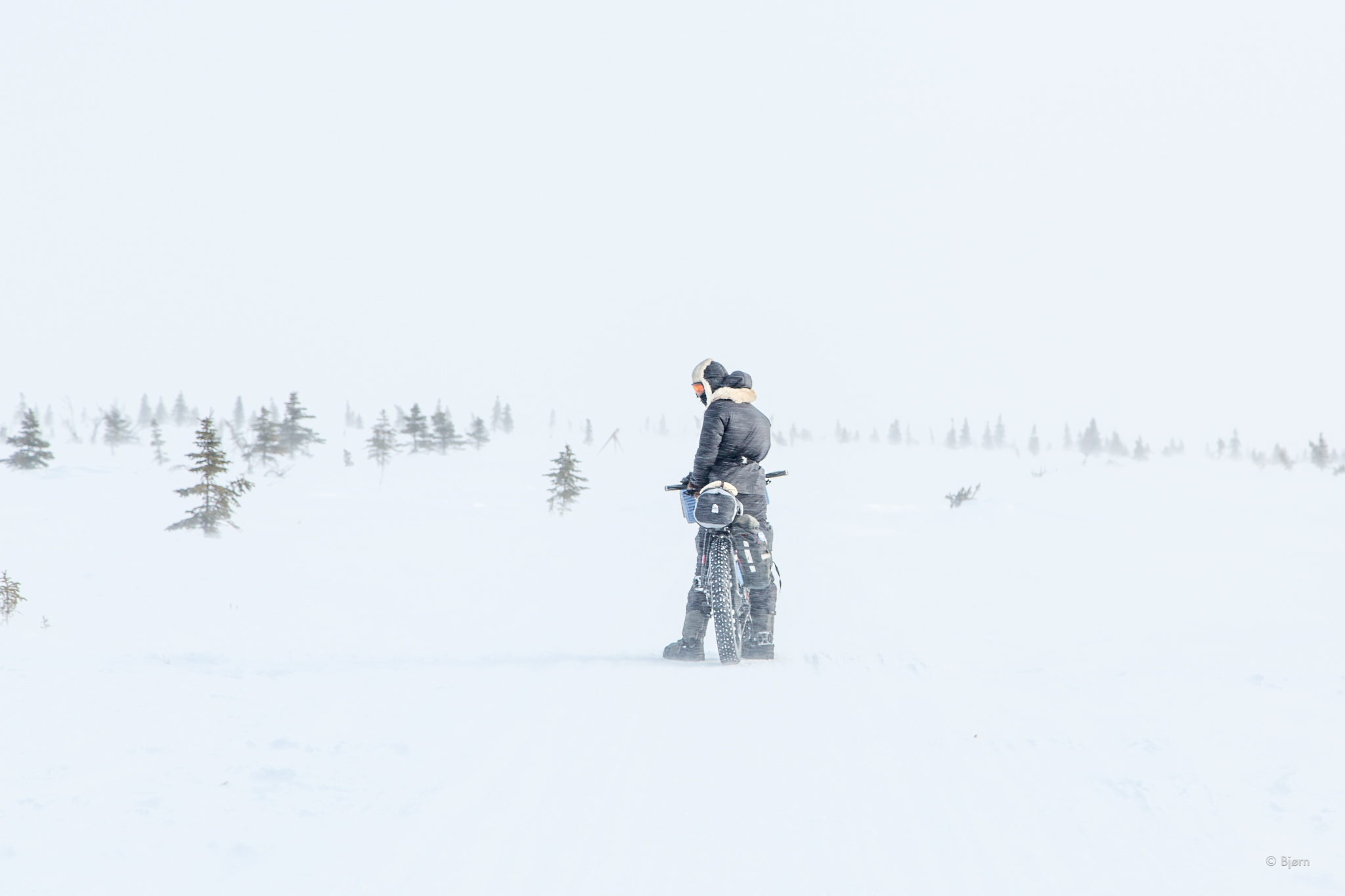 Kim McNett pauses in a blizzard outside of the village of Koyuk in March 2016. Bjørn Olson and Kim McNett biked from Nome to Kivalina in the late-winter/early spring of 2016 and encountered many storms and tough conditions during their trip. (Bjørn Olson)